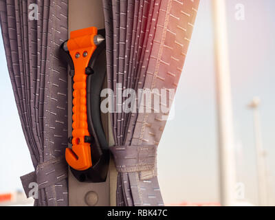 Orange Sicherheit hammer Montage in der Nähe der Fenster Glas und Vorhang auf dem Bus, verwenden Sie bei Unfall. Stockfoto