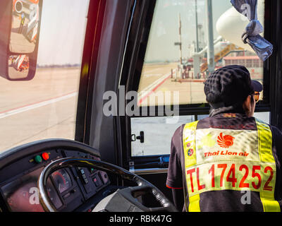 BANGKOK, THAILAND - November 5, 2018: Busfahrer, Thai Lion Air Personal in der Nähe vom Lenkrad sitzen warten auf Passagiere auf Shuttle Bus in Don Muang Stockfoto