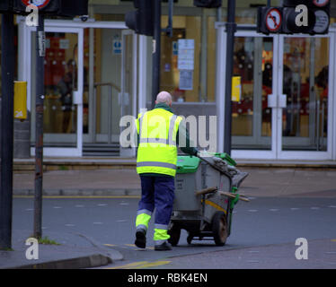 Müllmann Street Sweeper Kreuzung Straße schieben Staub Warenkorb mit Bürsten Stockfoto