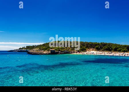 Schöner Strand mit türkisblauem Wasser überfüllt mit Touristen in der Cala Mondrago, Mallorca Stockfoto