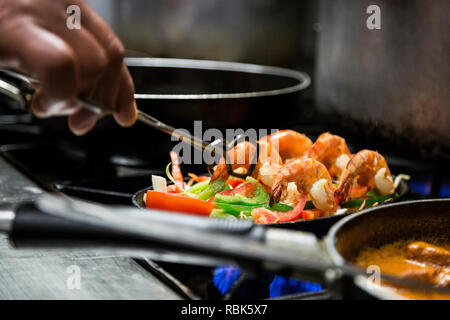 Mann kochen Garnelen auf dem Herd. Lecker und Sustainable Seafood, direkt vom Fischerboot auf den Tisch im Restaurant Stockfoto