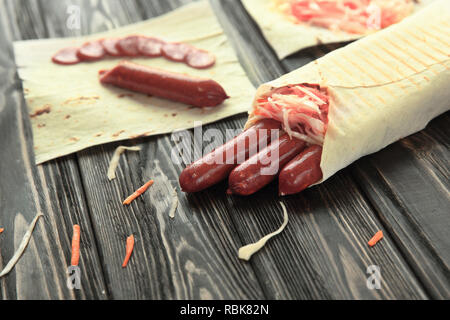 Geräucherte Wurst in pita Brot auf hölzernen Hintergrund Stockfoto