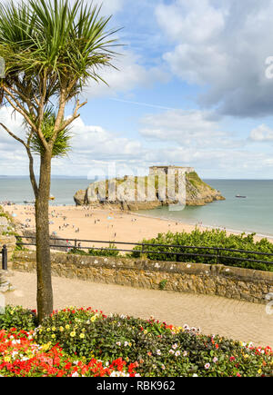 TENBY, Pembrokeshire, Wales - AUGUST 2018: Malerische Aussicht auf St. Catherine's Island und Castle Beach in Tenby, West Wales, mit einer Blume und einem Palm tr Stockfoto