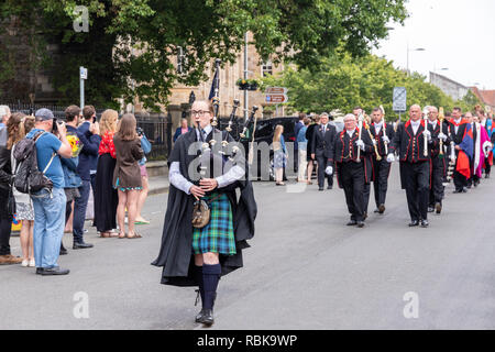 Ein Schottischer Tasche Piper führt die Prozession nach St. Andrews University Graduation Day im Juni 2018 den Norden Straße nach St. Salvators Quad, St Andrews Stockfoto
