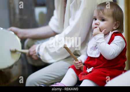 Belarus, Gomel, 24. November 2018. Wiederaufbau einer ethnischen alten Belarussischen Hochzeit. Baby mit Drum stick Stockfoto