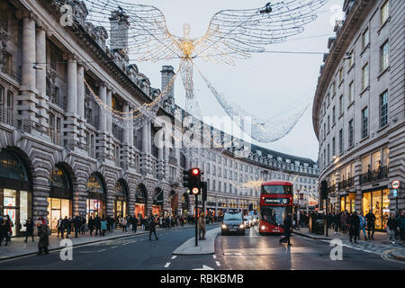 London, UK - Januar 5,2019: Busse, Autos und Fußgänger unter Engel Weihnachten Lichter auf der Regent Street am Abend, Bewegungsunschärfe. Regent Street ist Stockfoto