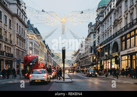 London, UK - Januar 5,2019: Busse, Autos und Fußgänger unter Engel Weihnachten Lichter auf der Regent Street am Abend, Bewegungsunschärfe. Regent Street ist Stockfoto