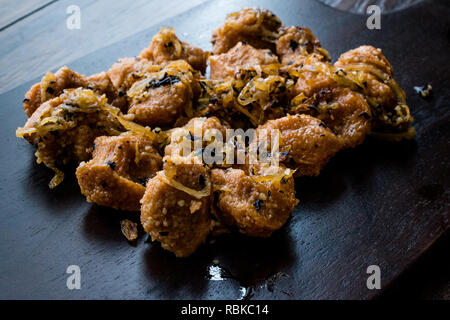 Türkische Sikma Köfte Bulgur Frikadellen mit karamellisierten Zwiebeln/Fellah Bulgur Köfte auf Holzbrett. Traditionelle Speisen. Stockfoto