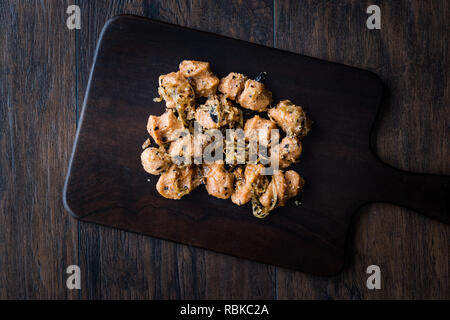 Türkische Sikma Köfte Bulgur Frikadellen mit karamellisierten Zwiebeln/Fellah Bulgur Köfte auf Holzbrett. Traditionelle Speisen. Stockfoto