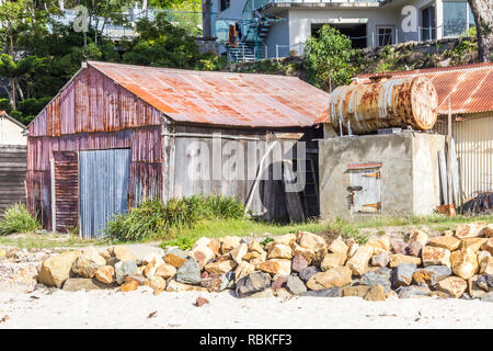 Wellpappe Hütte mit Öllager drum, Strand von Pambula Flussmündung, New South Wales, Australien Stockfoto