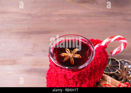 Detailansicht Glühwein mit Lollypop über braun Holz- Hintergrund mit Kopie Raum eingerichtet, Detailansicht Stockfoto