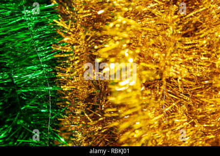 Close-up auf glänzenden gelben und grünen Lametta vertikal hängenden in der Feier von Weihnachten und das neue Jahr 2019. Dekoration für eine internationale Holida Stockfoto