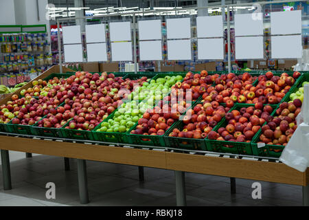 Ein großes Regal mit Körben mit verschiedenen Arten von Äpfeln im Obst Abteilung der Shopping Center. Frische und gesunde Lebensmittel für die tägliche Ernährung. Stockfoto