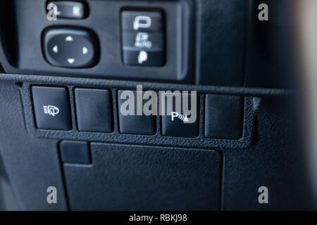 Einparkhilfe Taste auf der Mittelkonsole des Armaturenbretts im Auto von einem modernen Design in Schwarz mit weißen Zeichen und Symbole für die sichere d Stockfoto