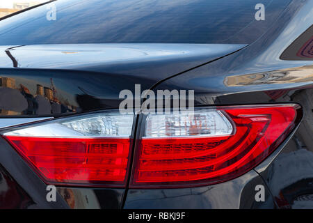 Die Rückseite des Close-up des Körpers und die Gestaltung der rot-weißen Scheinwerfer eines schwarzen Auto ist sauber und glänzend nach dem Waschen und Polieren der Trun Stockfoto