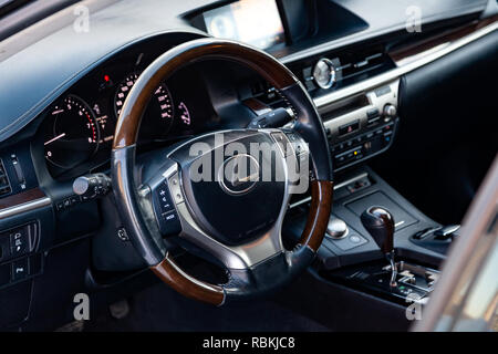 Moderne Lenkrad mit Holz Elemente und metallischem Chrom Teile in das Design eines teuren Lexus Auto auf dem Hintergrund der Control Panel und Stockfoto