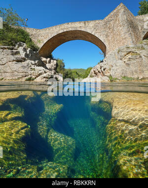 Fluss mit einer alten Steinbrücke und erodierten Felsen unter Wasser, geteilte Ansicht Hälfte oberhalb und unterhalb der Wasseroberfläche, Sant Llorenc de la Muga, Katalonien, Spanien Stockfoto