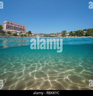 Spanien Strand mit einem Hotel in Llanca an der Costa Brava und einem sandigen Meeresboden Unterwasser, geteilte Ansicht Hälfte über und unter Wasser, Mittelmeer, Katalonien Stockfoto