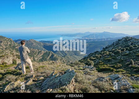 Spanien Landschaft, ein Mann stand am Blick von der Albera Berg mit dem Mittelmeer und Cap de Creus im Hintergrund, Pyrenäen, Katalonien Stockfoto