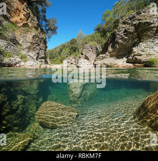 Wilder Fluss mit Felsen über und Unterwasser, geteilte Ansicht Hälfte oberhalb und unterhalb der Wasseroberfläche, la Muga, Katalonien, Spanien Stockfoto