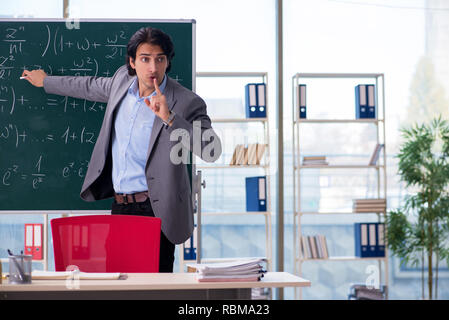 Junge schöne Mathematik Lehrer im Klassenzimmer Stockfoto