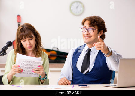 Junge Frau während der musikstunde mit männlichen Lehrer Stockfoto