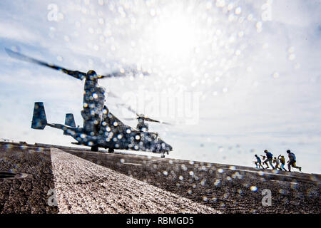 190102-N-PH 222-1141 Arabische Meer (Jan. 2, 2018) Matrosen zu San Antonio zugeordnet - Klasse amphibious Transport dock USS Anchorage LPD (23) und die US-Marines, die dem zugeordnet 13 Marine Expeditionary Unit (MEU) laufen mit Keilen und Ketten ein MV-22 Osprey tiltrotor Aircraft, Marine Medium Tiltrotor Squadron (VMM) 166 (verstärkt), während auf einer Bereitstellung der Essex Amphibious Ready Group (ARG) und 13th Marine Expeditionary Unit (MEU). Das Essex ARG/13 MEU ist flexibel und anhaltende Navy-Marine Corps Team in die USA 5 Flotte Bereich für Maßnahmen zur Erhöhung der Marineoperationen bereitgestellt ensur Stockfoto