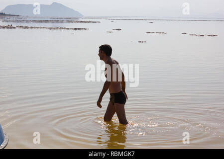 Ein Mann ist zu Fuß in flachen Gewässern von salt lake Urmia, West Provinz Aserbaidschan, Iran Stockfoto