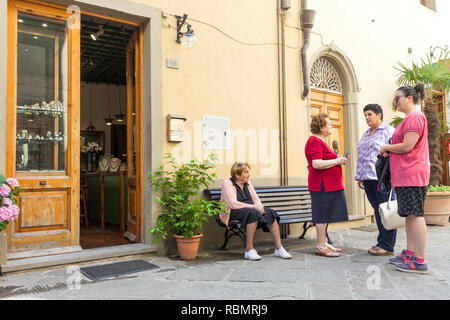 Gruppe von lokalen mittleren Alters und ältere Frauen Geselligkeit auf der Straße in der alten italienischen Stadt von Castellina in Chianti auf warmen Sommertag Stockfoto