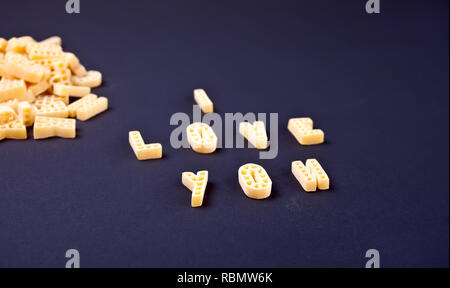 Text Ich liebe dich mit Makkaroni in Form von Buchstaben auf schwarzem Holz- Tabelle geschrieben Stockfoto