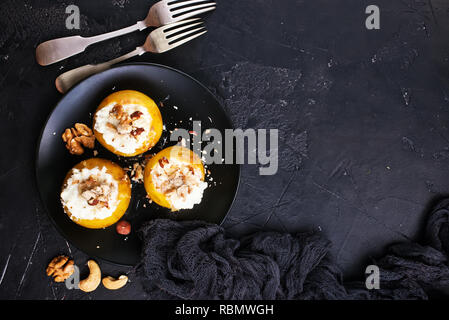 Gebackene Äpfel mit Nüssen und Honig, Wüste auf der Platte Stockfoto