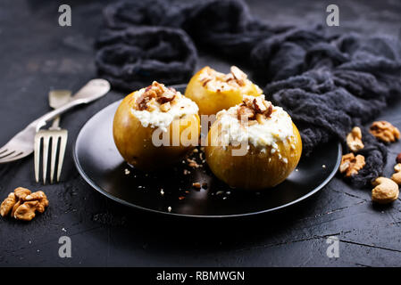 Gebackene Äpfel mit Nüssen und Honig, Wüste auf der Platte Stockfoto