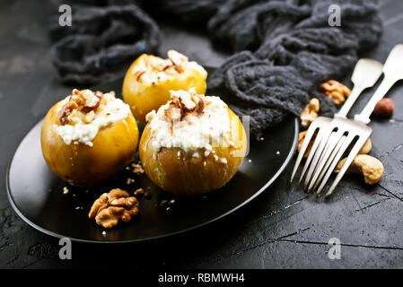 Gebackene Äpfel mit Nüssen und Honig, Wüste auf der Platte Stockfoto