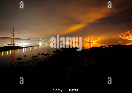 Reflexionen der Firth-of-Forth Road and Railway Bridge bei Nacht in Queensferry, Schottland. Stockfoto