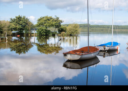Idylle mit kleinen Segelboote im Wasser widerspiegelt Stockfoto