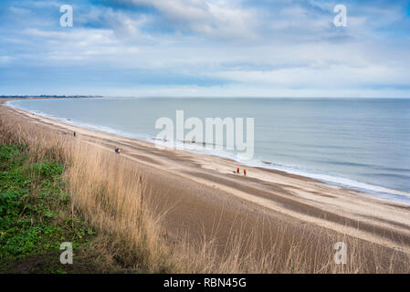 Dunwich Strand Suffolk, Blick von den Klippen mit Blick auf Dunwich Strand von Menschen zu Fuß entlang der Küste von Suffolk, England, UK. Stockfoto