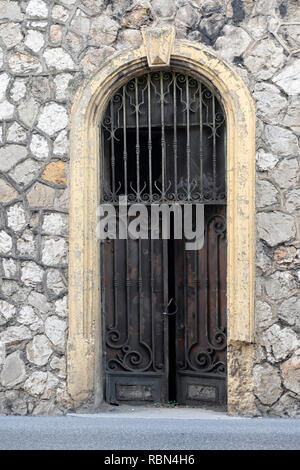 MONTE CARLO, MONACO: 26. MAI 2018: Teilweise geöffnet Altes Holzbogendatum in Steinmauer Stockfoto