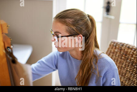 Weibliche Teenager Künstler sitzen an Staffelei Zeichnung Bild Stockfoto