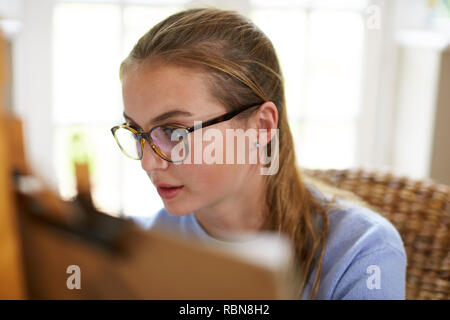 Weibliche Teenager Künstler sitzen an Staffelei Zeichnung Bild Stockfoto