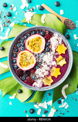 Lecker appetitlichen Smoothie acai Schale von Brombeeren und wilde Beeren, mit Passionsfrucht, Kokosflocken dekoriert, und Kakao Nibs. Serviert Stockfoto