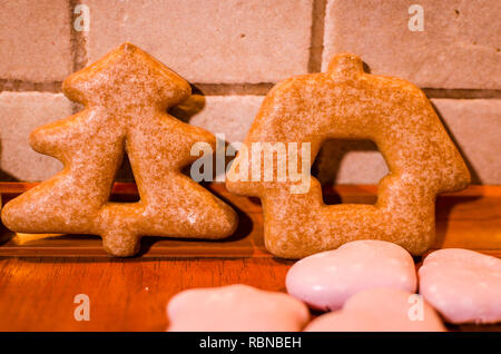 Weihnachten Lebkuchen wie ein Weihnachtsbaum und ein Haus mit wenig pink Cookies auf der Arbeitsplatte in der Küche geprägt Stockfoto