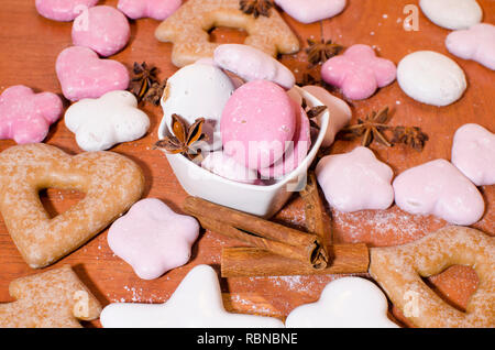 Weiß und rosa Weihnachten Lebkuchen in einer Schüssel mit einem Sternanis und Zimtstangen auf einer hölzernen Küchentisch Stockfoto