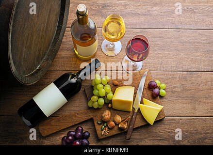 Gläser und Flaschen Rotwein und Weißwein auf hölzernen Hintergrund Stockfoto