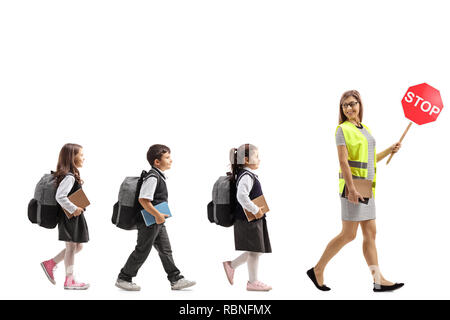 Volle Länge Profil der Schule Lehrer mit einer warnweste und stop-Schild zu Fuß mit Schülern auf weißem Hintergrund Stockfoto
