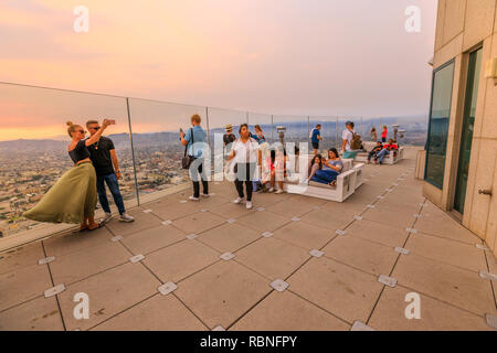 Los Angeles, Kalifornien, Vereinigte Staaten - 9 August, 2018: Paar unter selfie auf offenen Terrasse bei Sonnenuntergang. Menschen mit Blick auf die La der Skyline der Innenstadt von Oue Skyspace U.S. Bank Tower. Stockfoto