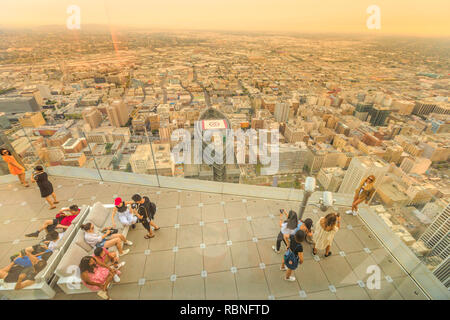 Los Angeles, Kalifornien, Vereinigte Staaten - 9. August 2018: Luftaufnahme von Touristen unter Foto auf der Panoramaterrasse in der Dämmerung. Die Menschen in LA Downtown Skyline von Oue Skyspace U.S. Bank Tower suchen. Stockfoto