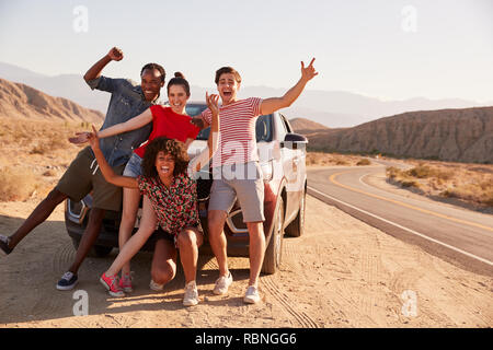 Junge Erwachsene Freunde auf Straße Reise viel Spaß beim Posieren mit dem Auto Stockfoto