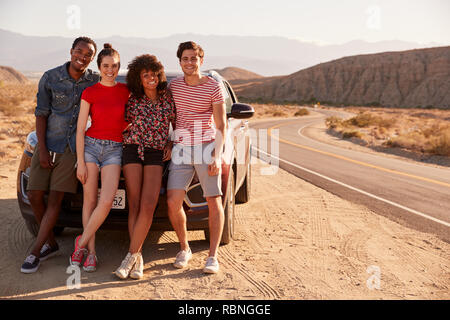 Junge Erwachsene Freunde auf eine Reise gönnen Sie sich eine Pause, die ihr Fahrzeug Stockfoto