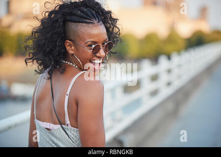 Trendy Frau in gestreiftem Hemd und Sonnenbrille, Drehen Stockfoto