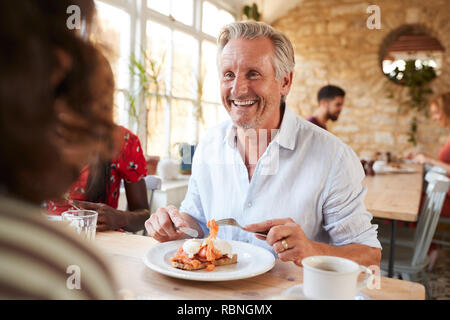 Gerne älteren weißen Mann essen Brunch mit Freunden in einem Cafe Stockfoto